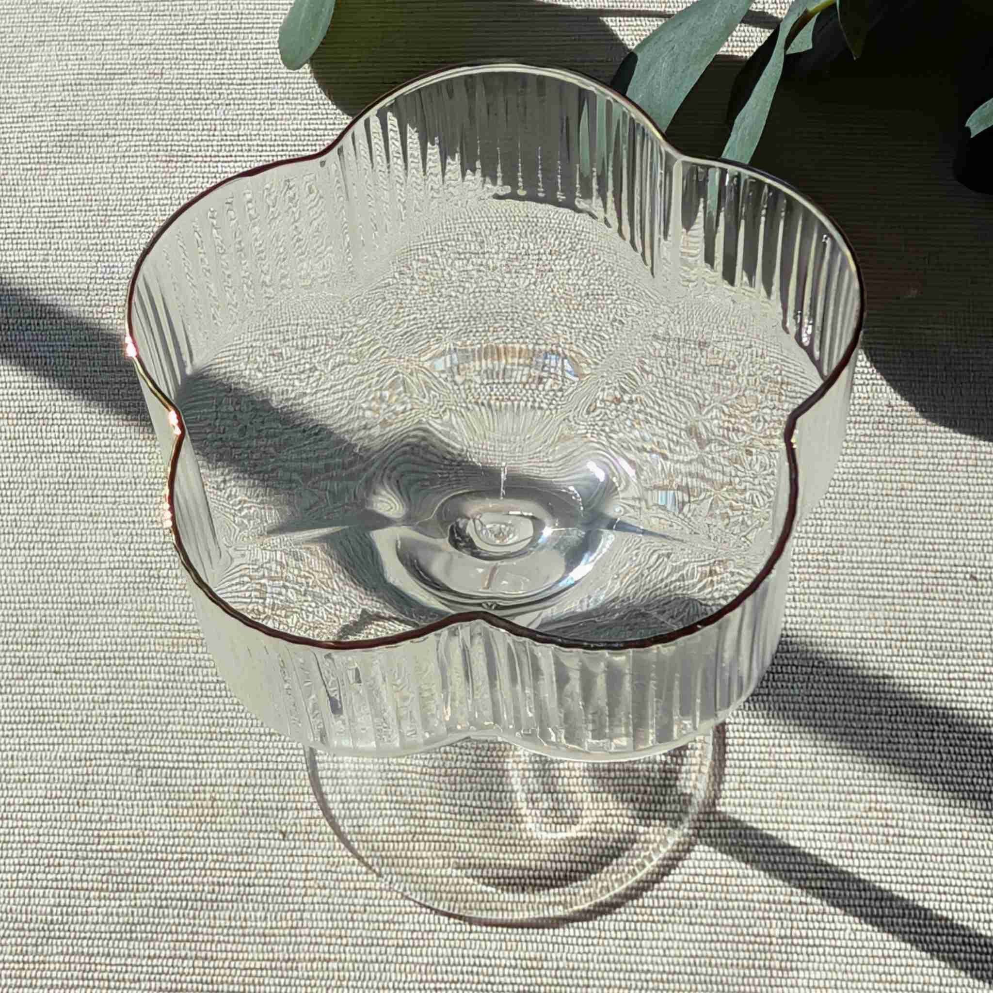 Flower-shaped glass coupe with ribbed design and gold rim, elegant stemmed glassware for cocktails, desserts, or special occasions