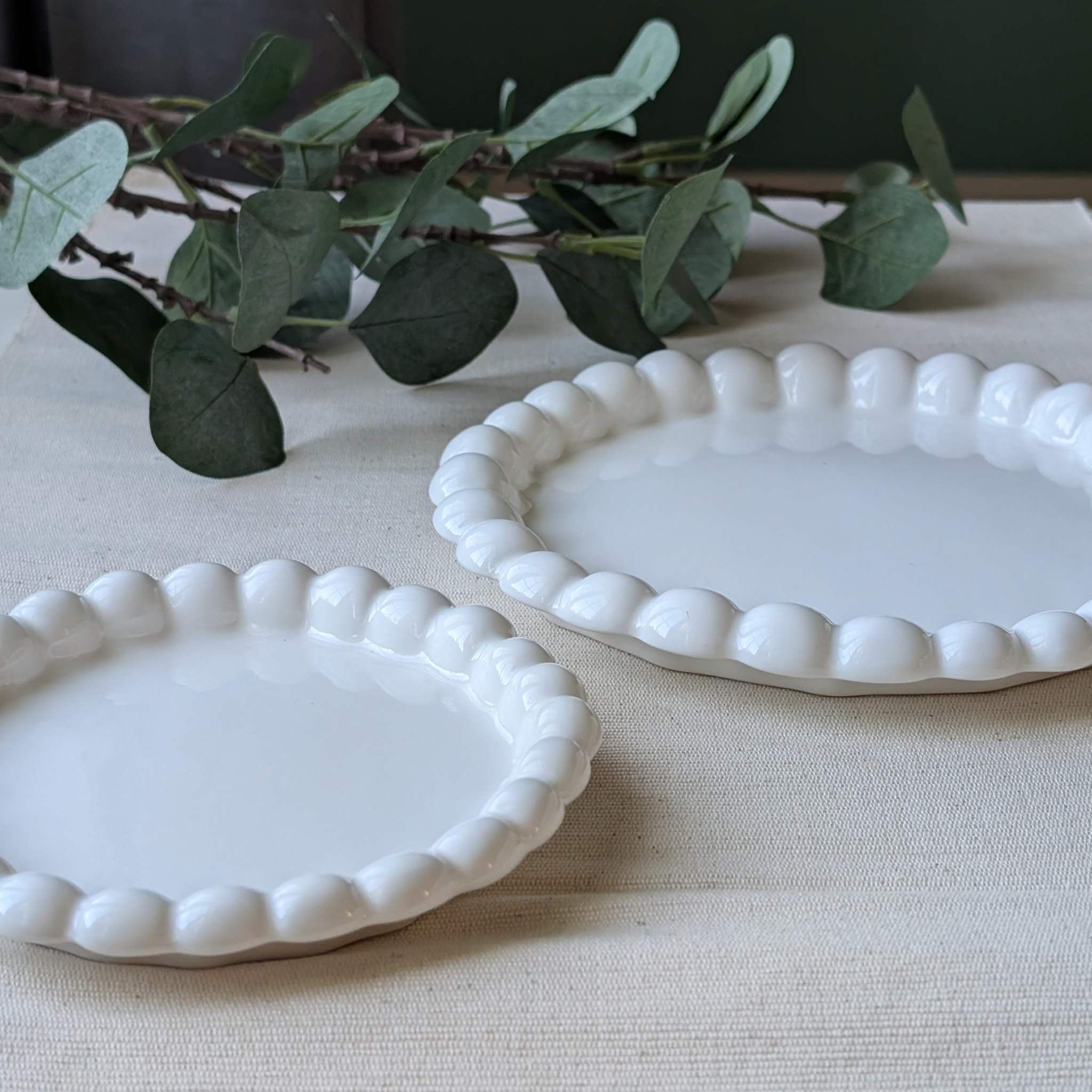 Set of white curved-edge ceramic plates in two sizes