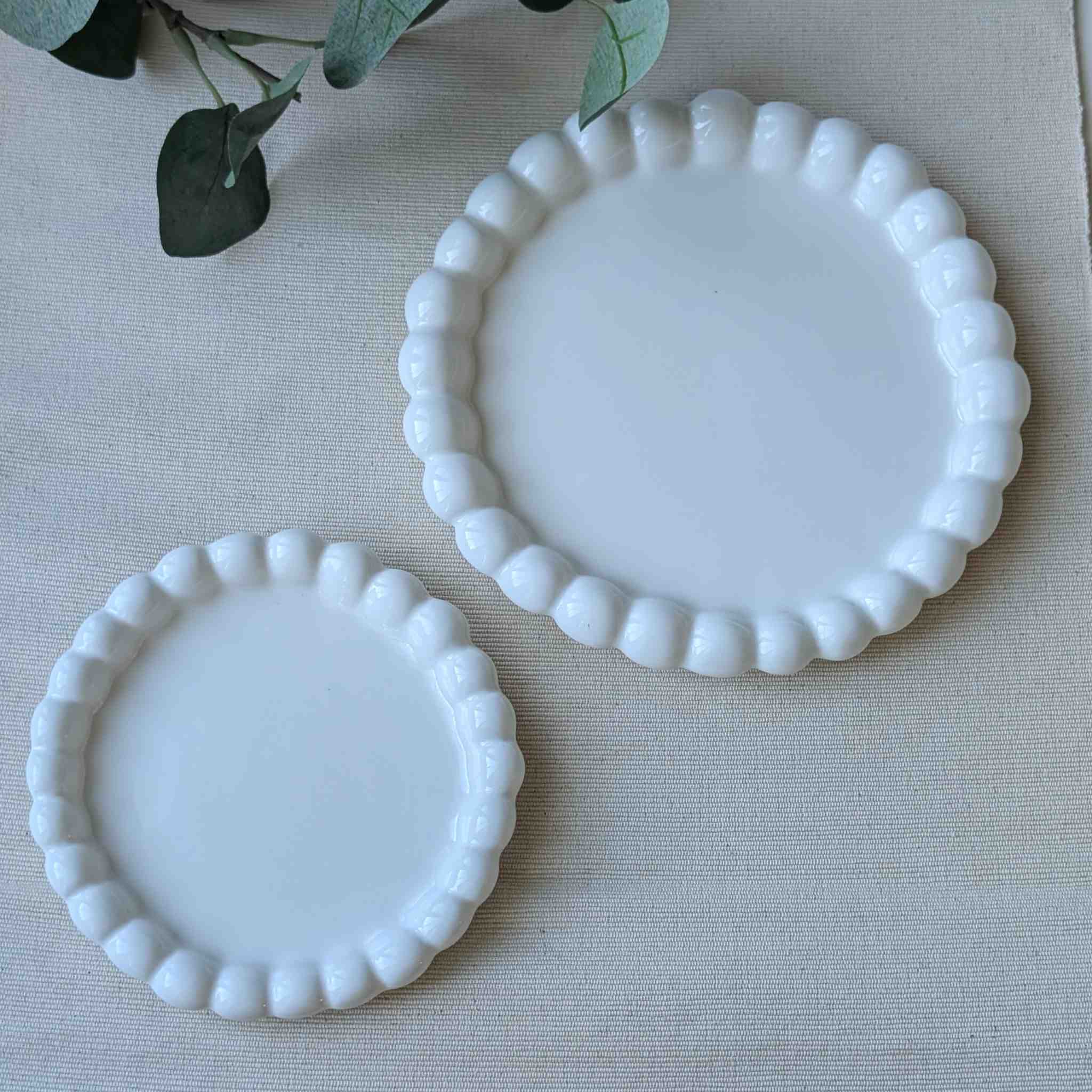 Set of white curved-edge ceramic plates in two sizes