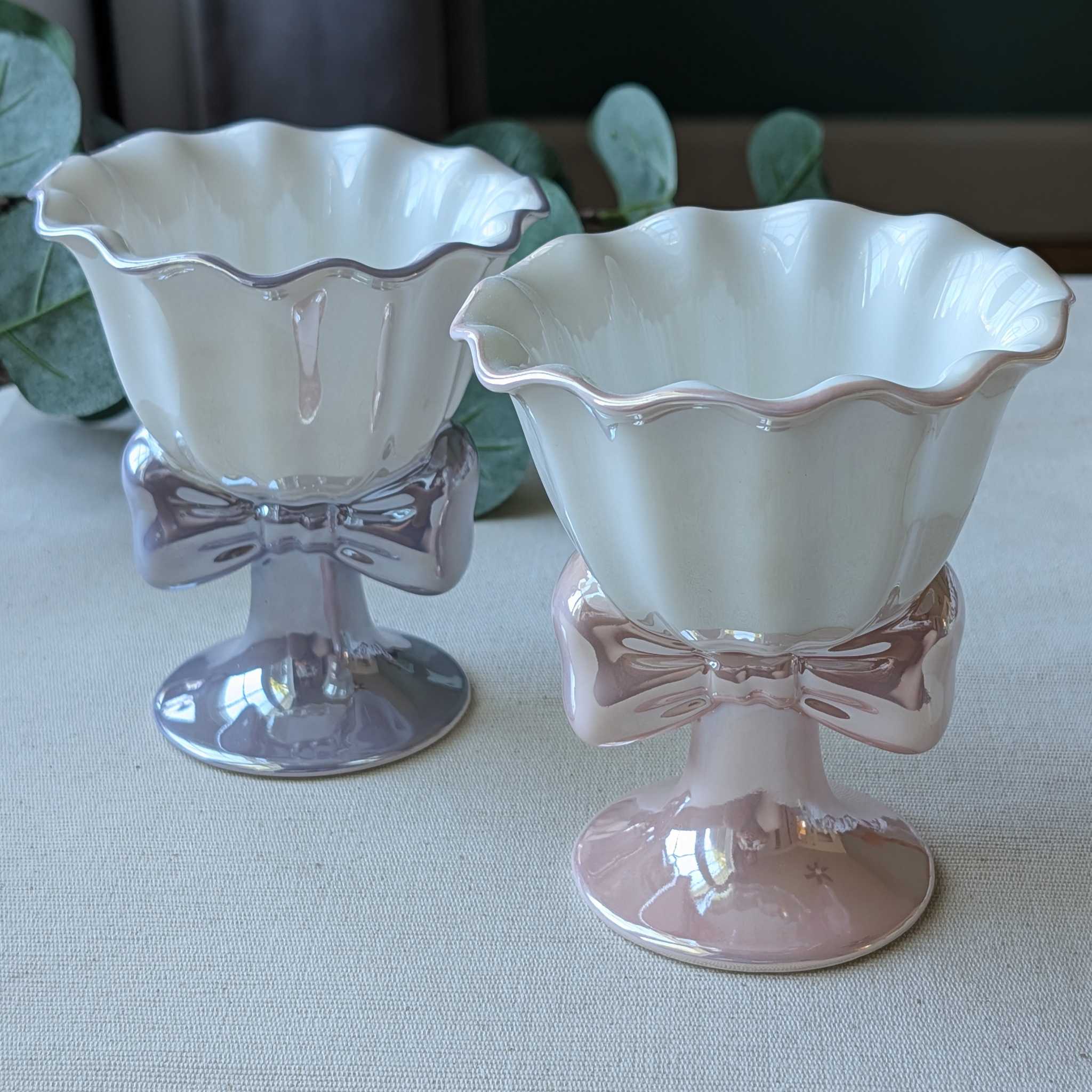Elegant ceramic dessert cups with scalloped rims and bow-shaped bases in pink and lavender