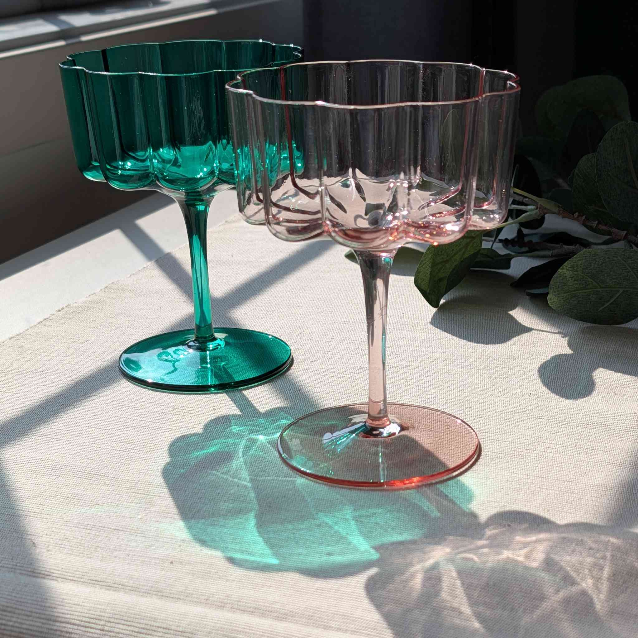Set of flower petal cocktail, dessert, and wine glasses in green and pink, elegant stemware with scalloped design