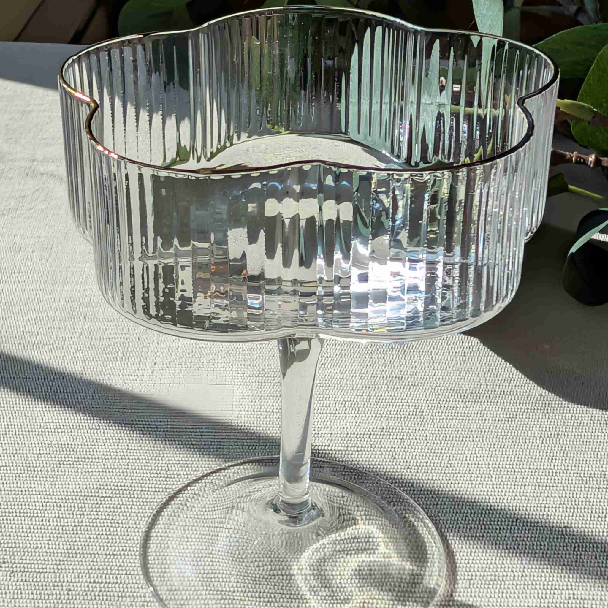 Flower-shaped glass coupe with ribbed design and gold rim, elegant stemmed glassware for cocktails, desserts, or special occasions