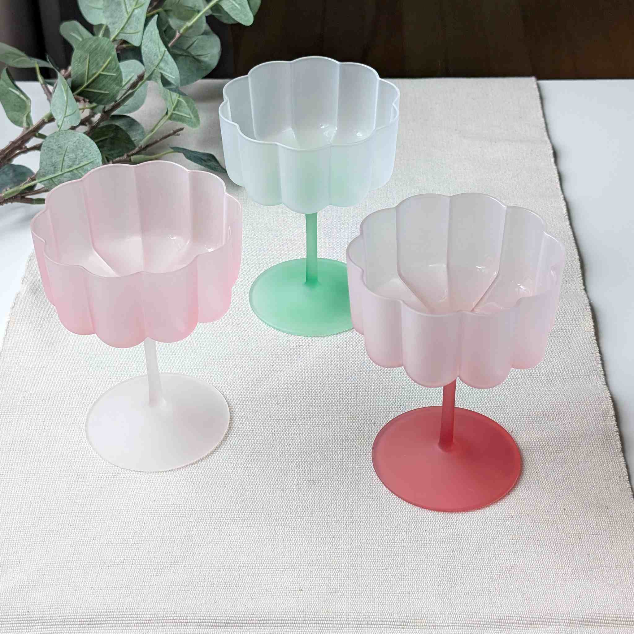 Set of pastel flower-shaped scalloped glasses in pink and green, perfect for cocktails, wine, or desserts