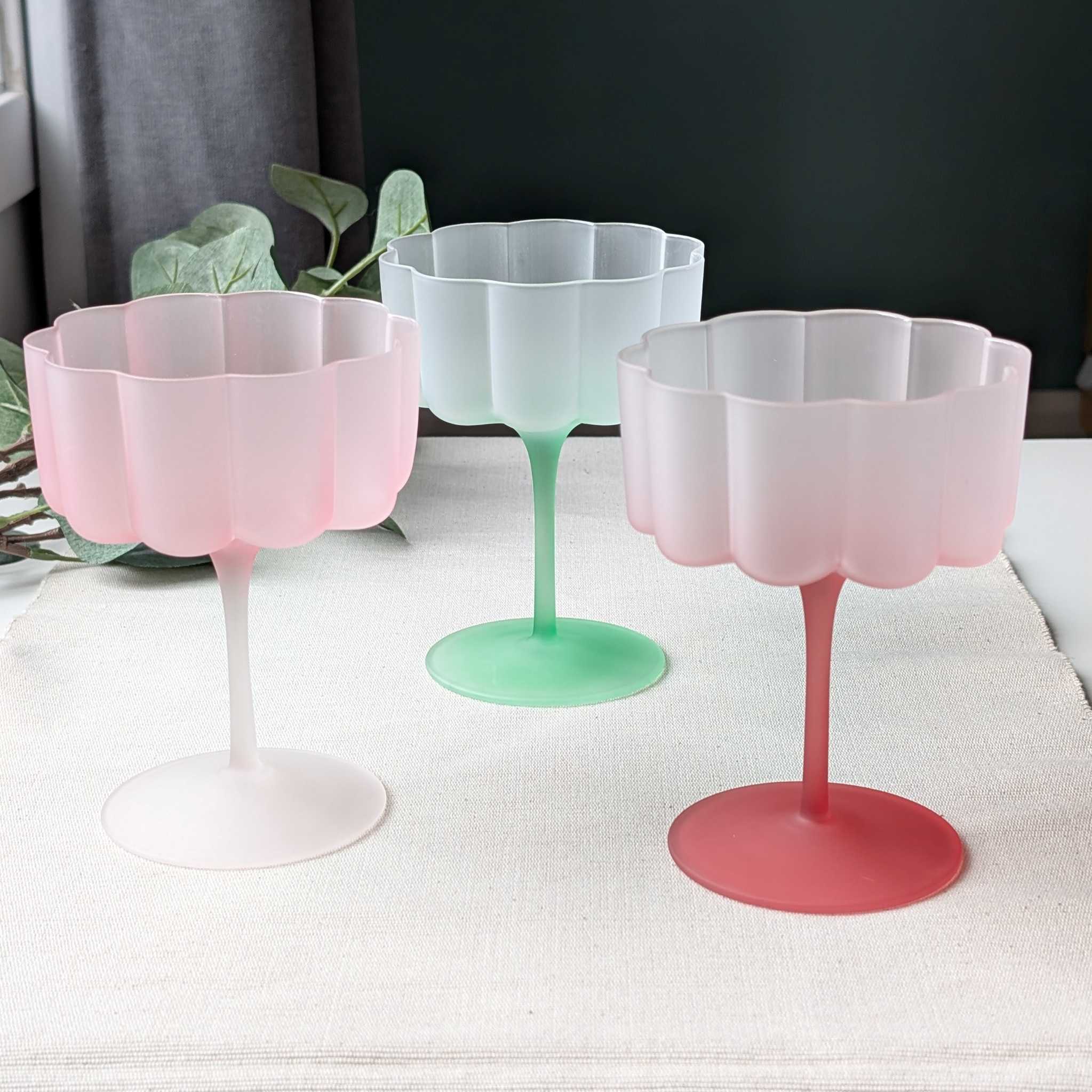 Set of pastel flower-shaped scalloped glasses in pink and green, perfect for cocktails, wine, or desserts