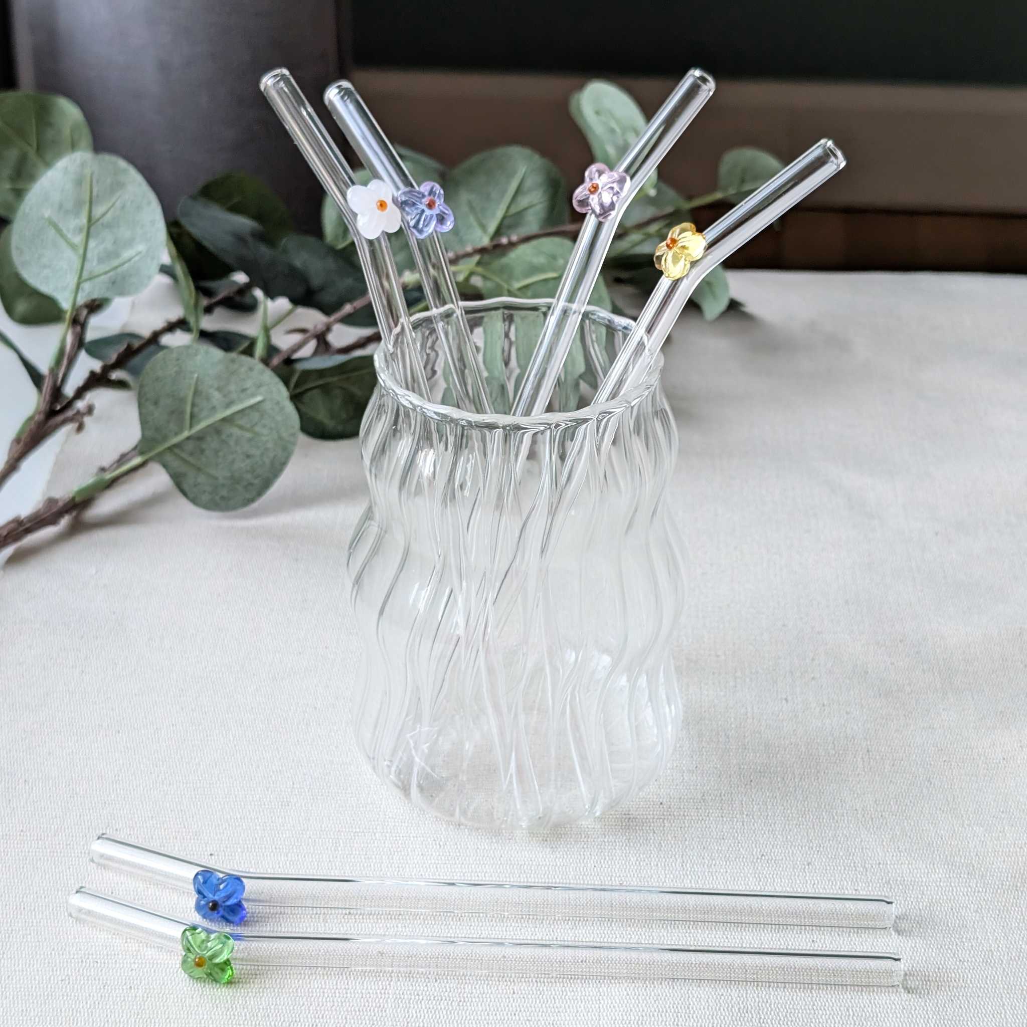 Set of reusable glass straws adorned with delicate flower details in pink, white, yellow, green, and blue