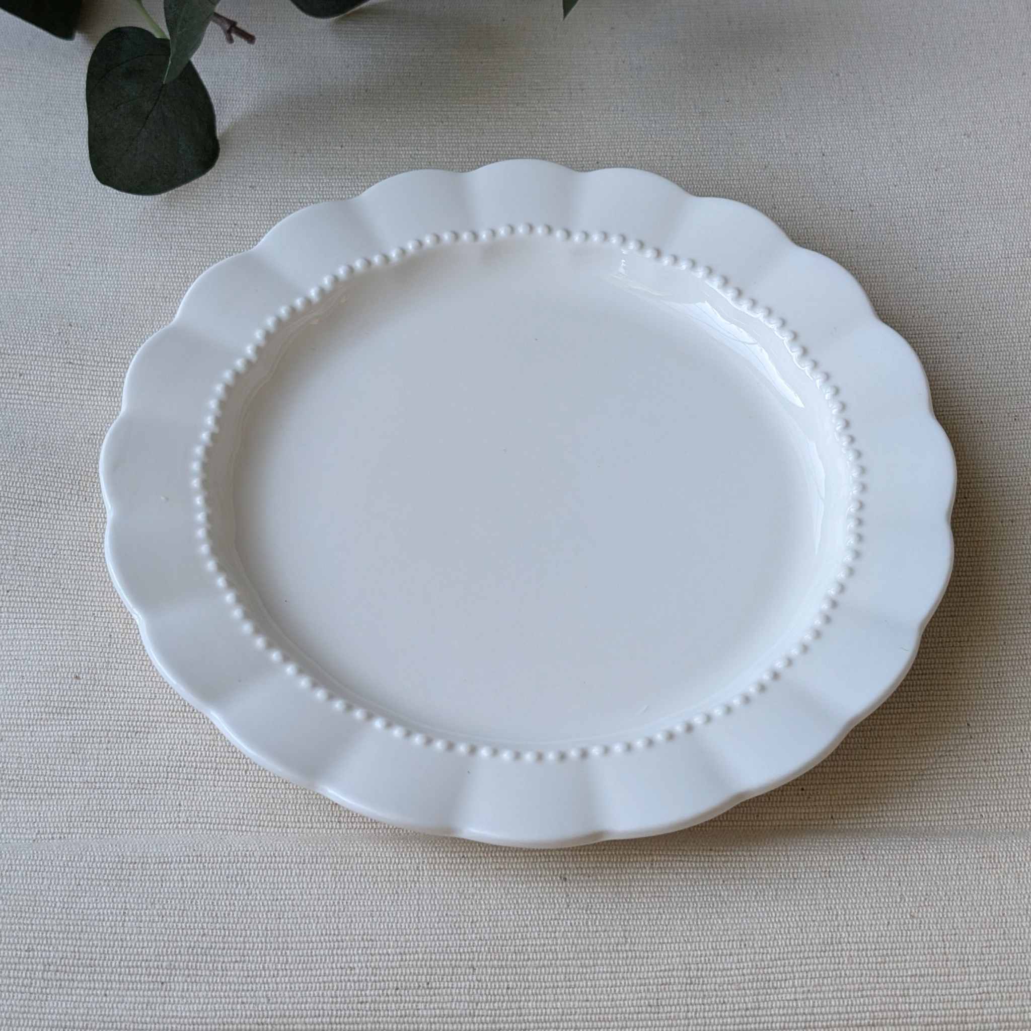 Elegant white scalloped ceramic plate with a delicate beaded rim
