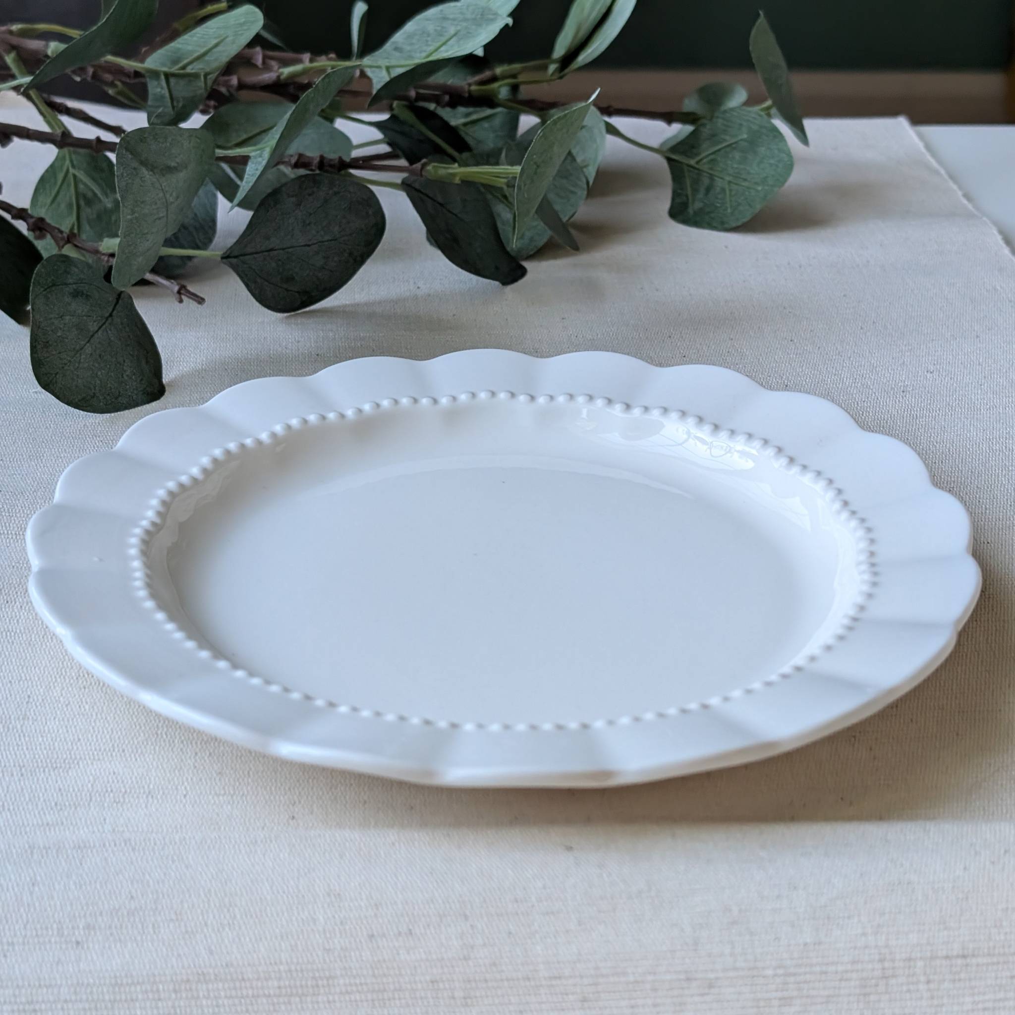 Elegant white scalloped ceramic plate with a delicate beaded rim