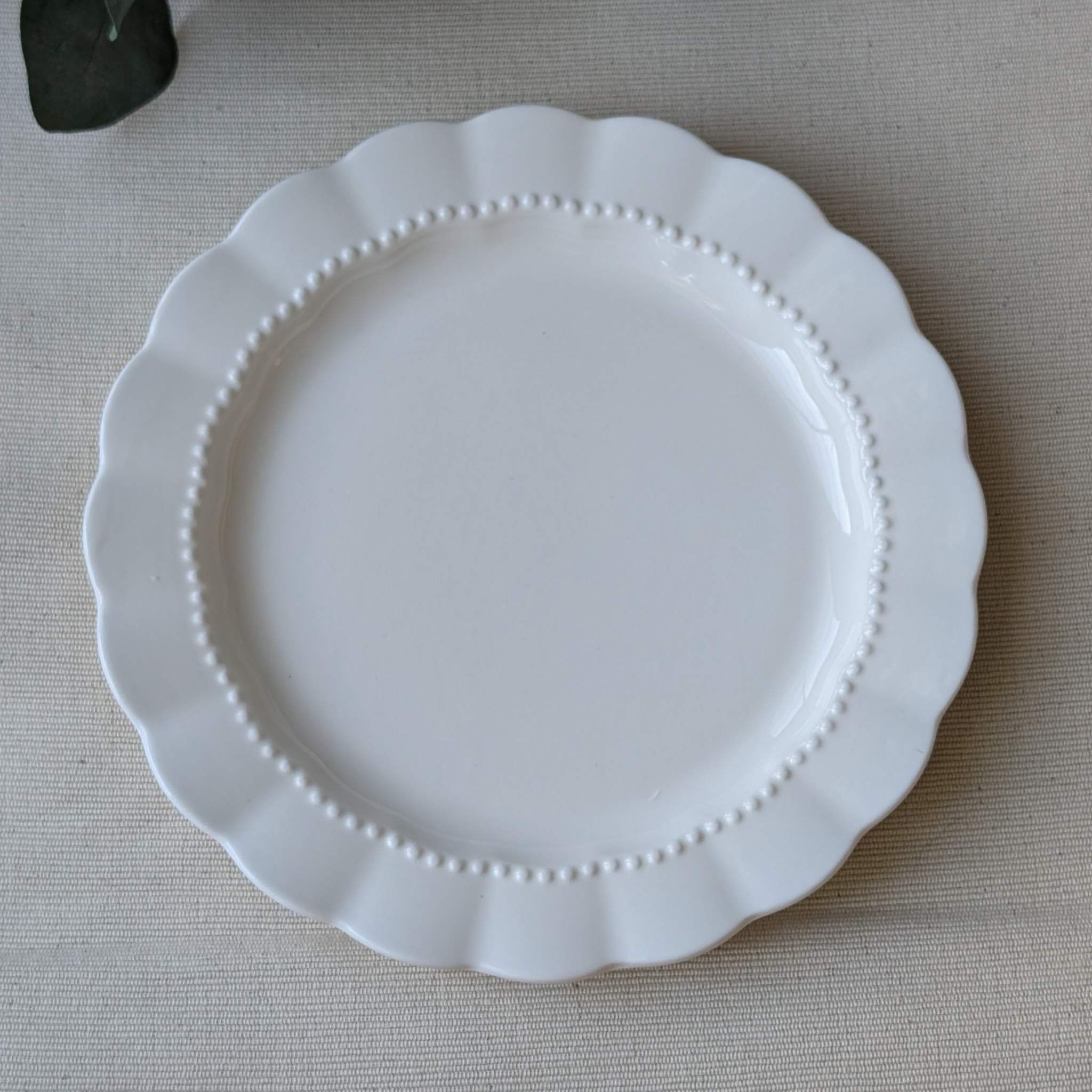 Elegant white scalloped ceramic plate with a delicate beaded rim