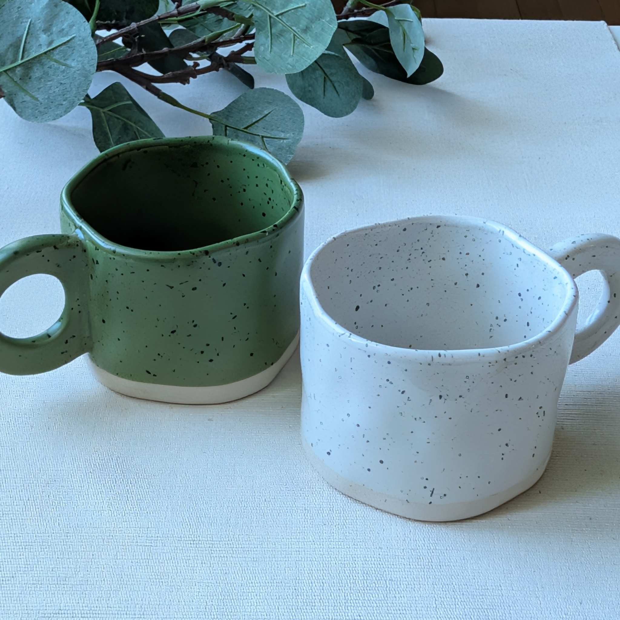 Speckled ceramic mugs in green and white