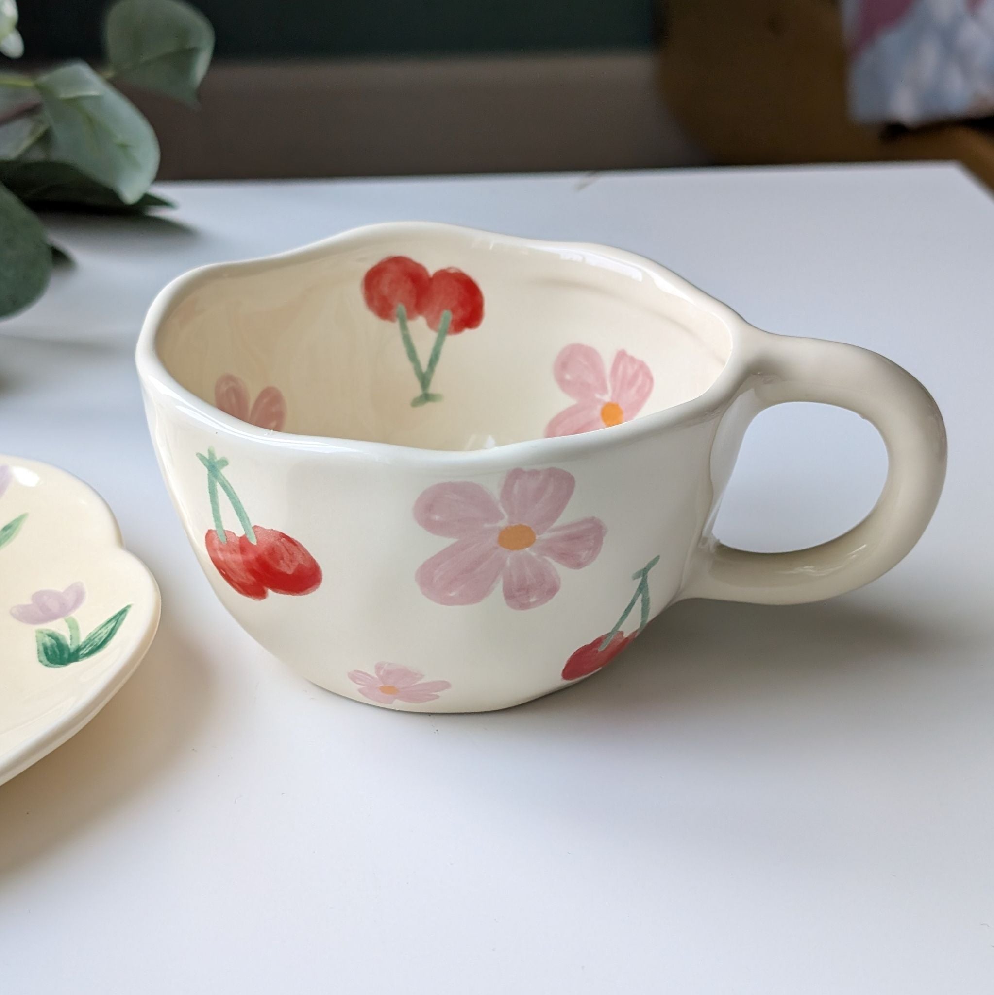 Wavy cream ceramic cup with floral and cherry design