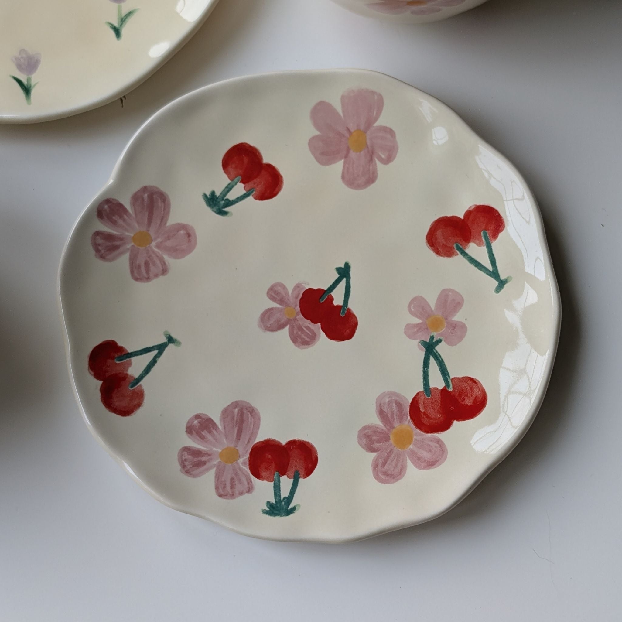 Wavy cream ceramic plate with floral and cherry design