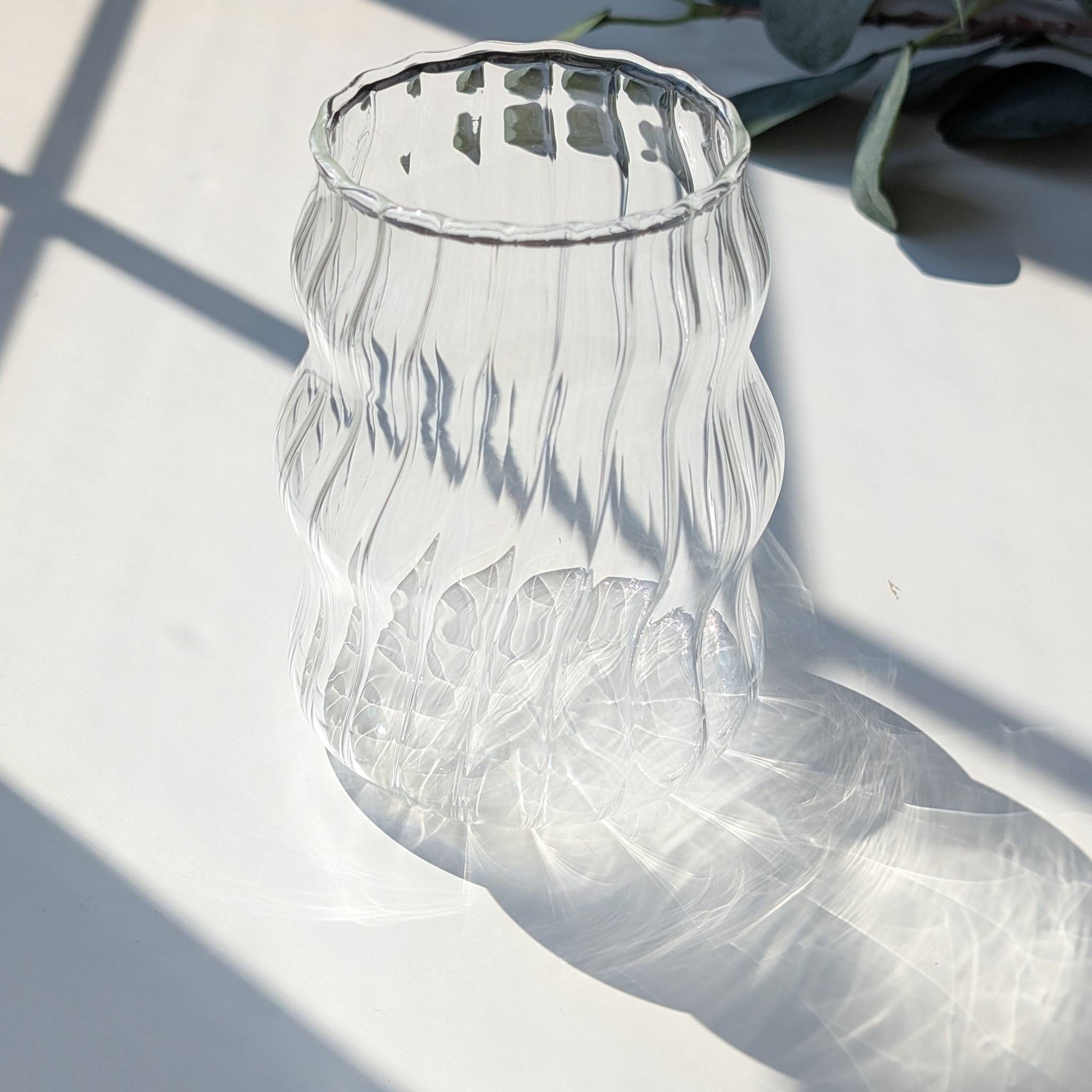 Clear wavy ribbed glass cup with a textured design, modern tumbler