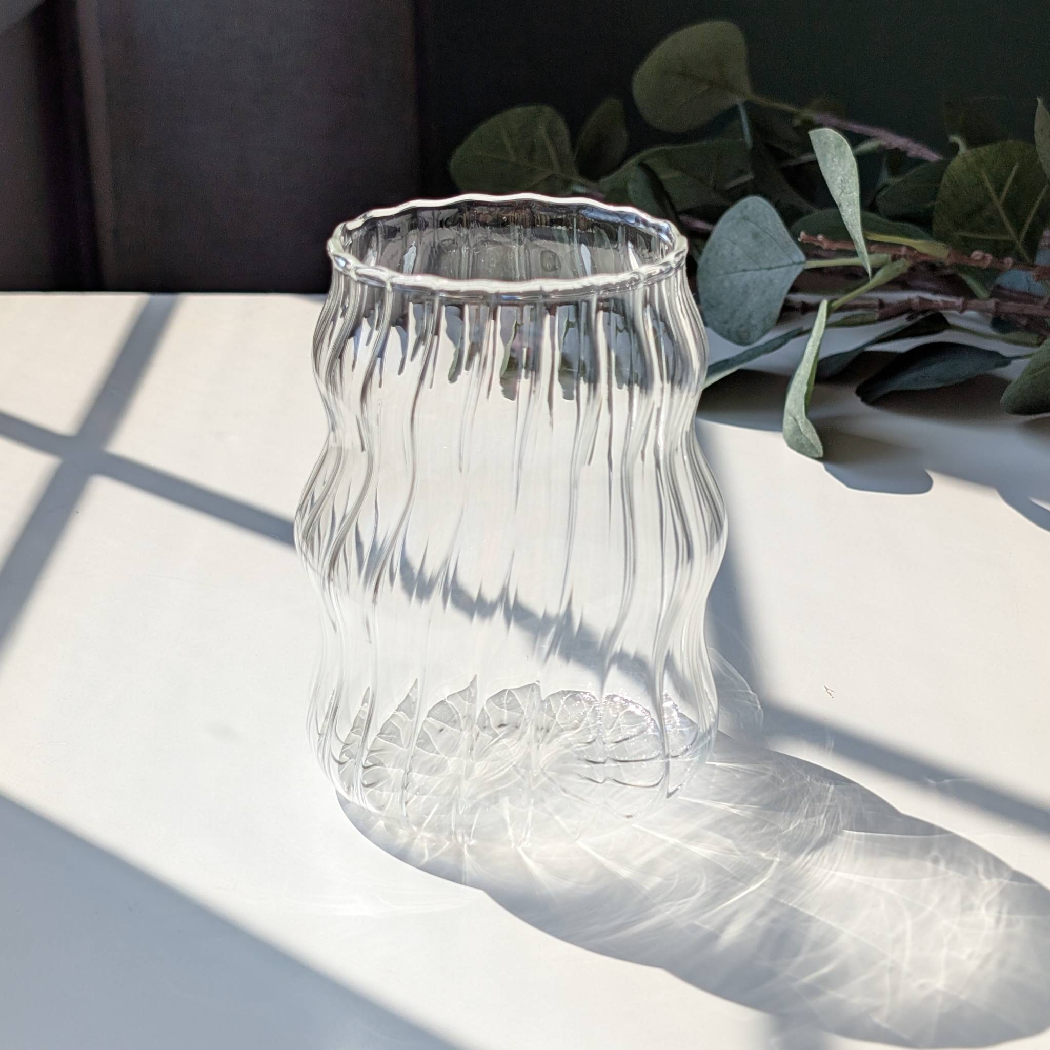 Clear wavy ribbed glass cup with a textured design, modern tumbler