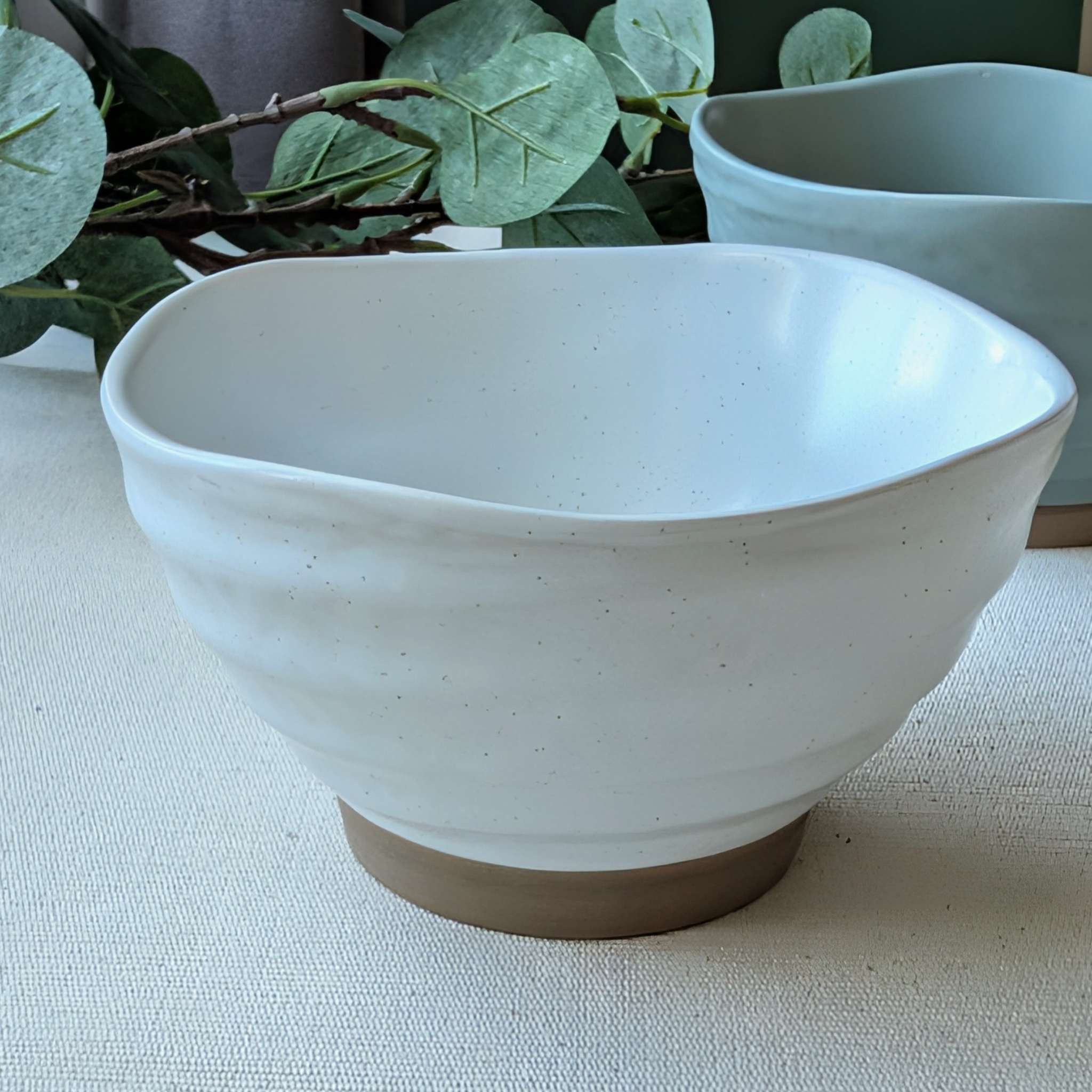 White wavy speckled ceramic bowl with natural clay base